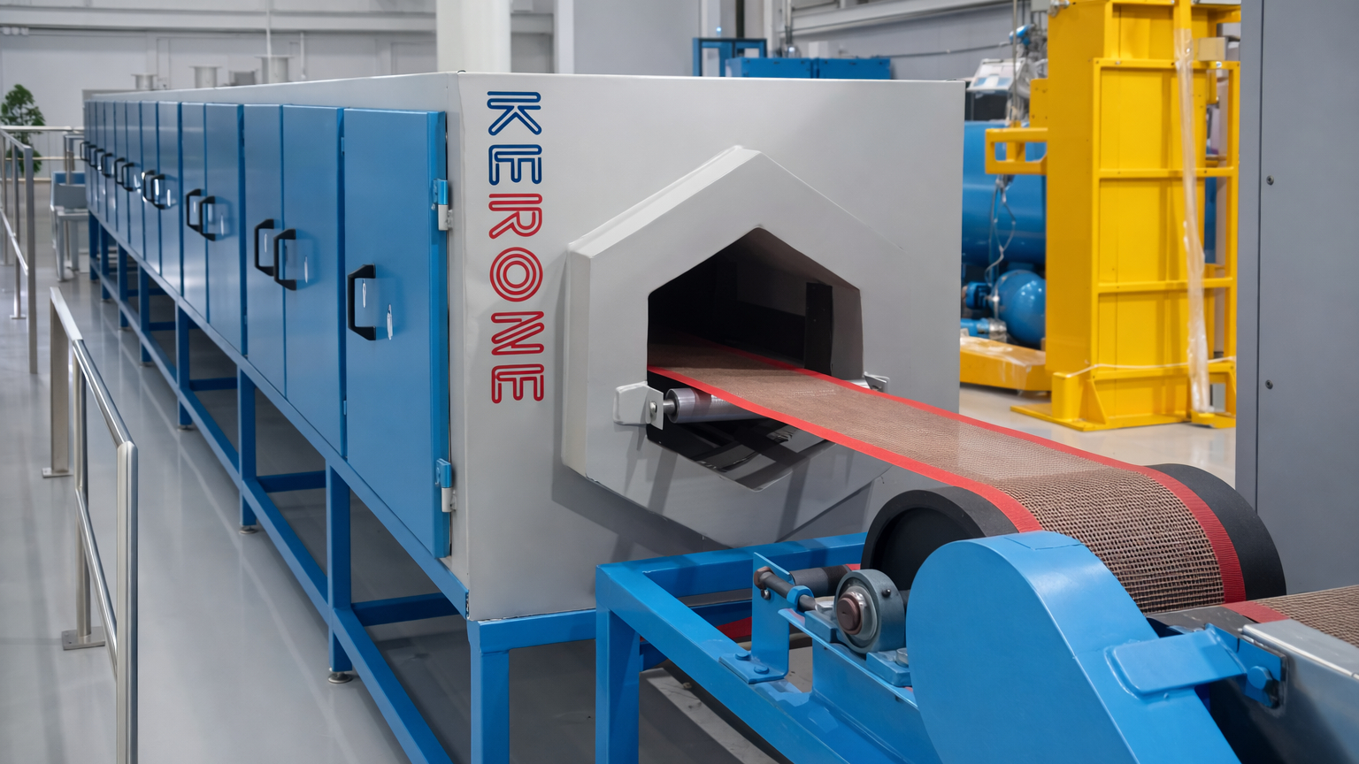 Industrial microwave processing machine with a conveyor belt transporting a continuous rubber sheet through a multi-chamber heating tunnel.